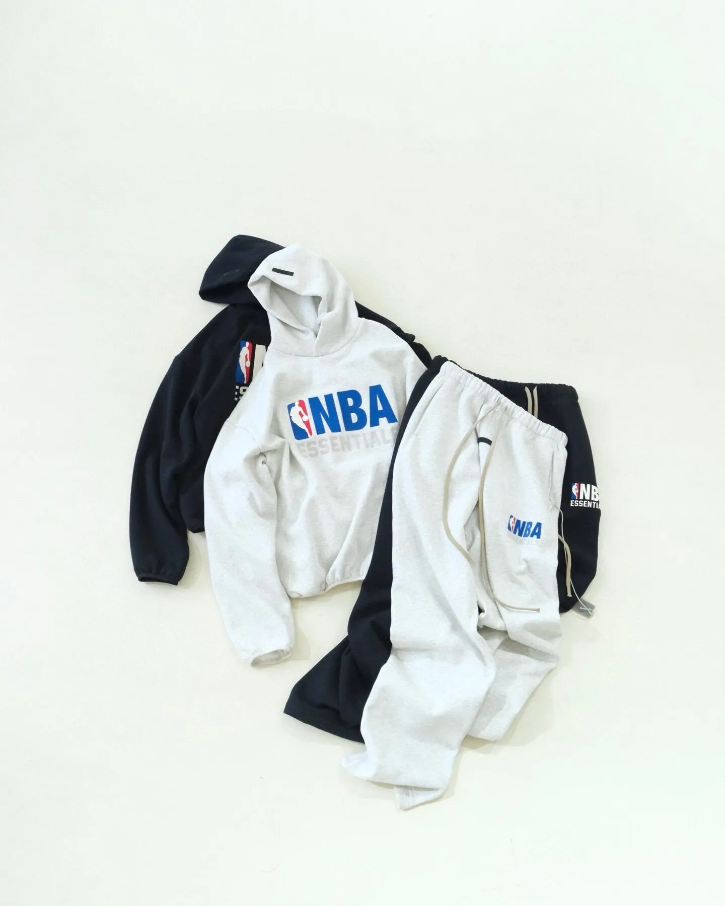 (Top) Fear of God double-line Essentials x NBA joint model FW 25 Essentials NBA Hoodie hooded sweatshirt with flocked printed logo lettering on the chest: When the street trend meets the passion for basketball, the joint hooded sweatshirt between Essentials and NBA was born, opening a new chapter in fashion. From the design point of view, the sweatshirt is presented in a Classic version, which is loose and moderate. Whether it is daily travel or sports and leisure, it can give the body a comfortable wrapping feeling. The iconic NBA logo on the chest is brightly colored and highly recognizable, and complements Essentials' simple brand font. The cuffs and hem are all hemmed, cleverly integrating the characteristic elements of the two brands to highlight its unique identity. In terms of materials, high-quality fabrics are selected. The gram-washed velvet fabric does not shrink or deform, and feels soft and skin-friendly, as if it is a layer of gentle care for the skin. The thermal insulation performance is also very good. In the slightly cooler season, it can protect you from the cold and keep you warm at all times. At the same time, the fabric has good breathability, making it less likely to feel stuffy even after exercise, and always keeping you fresh and comfortable. Wear it on the street and you will be the center of attention. Whether paired with casual jeans for a casual look, or sports leggings for a dynamic look, you can easily control different styles. It is not only a piece of clothing, but also a carrier of trend culture and basketball spirit. It brings the uninhibitedness of the street and the passion of basketball, allowing you to stand out from the crowd and show your own style with confidence. Meteorite black, light fog gray: SM L XL S 80-140 catties M 140-160 catties L 160-180 catties XL 180 catties